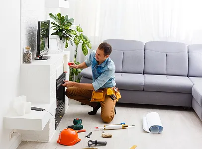 Homme réparant une cheminée, outils sur le sol dans un salon moderne à Sainte Gemme la Plaine près de Luçon en Vendée 85