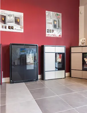 Salle d'exposition avec poêles à granulés modernes devant un mur rouge à Sainte Gemme la Plaine près de Luçon en Vendée 85